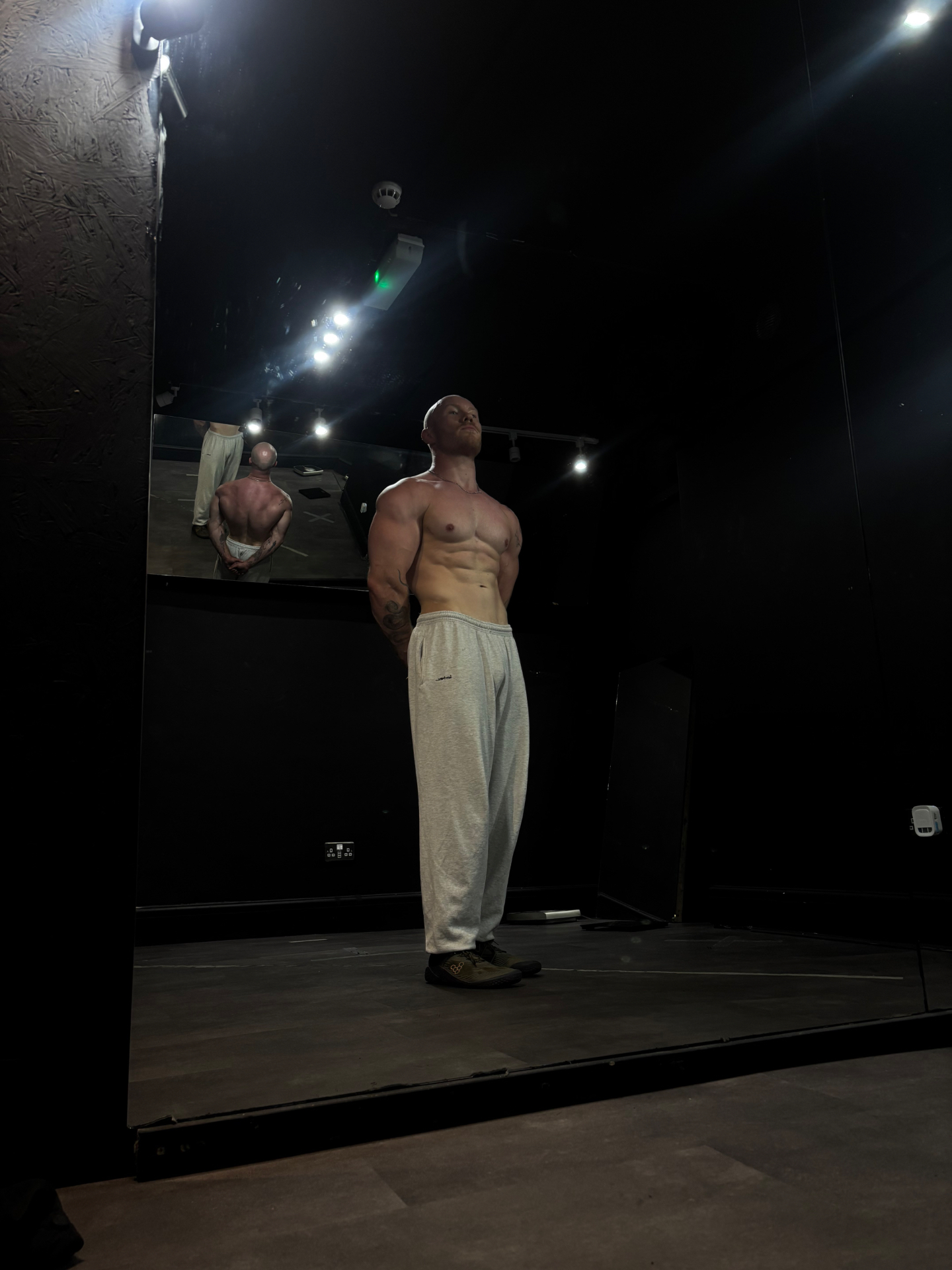 James Davies standing under stage lighting, lean and conditioned physique